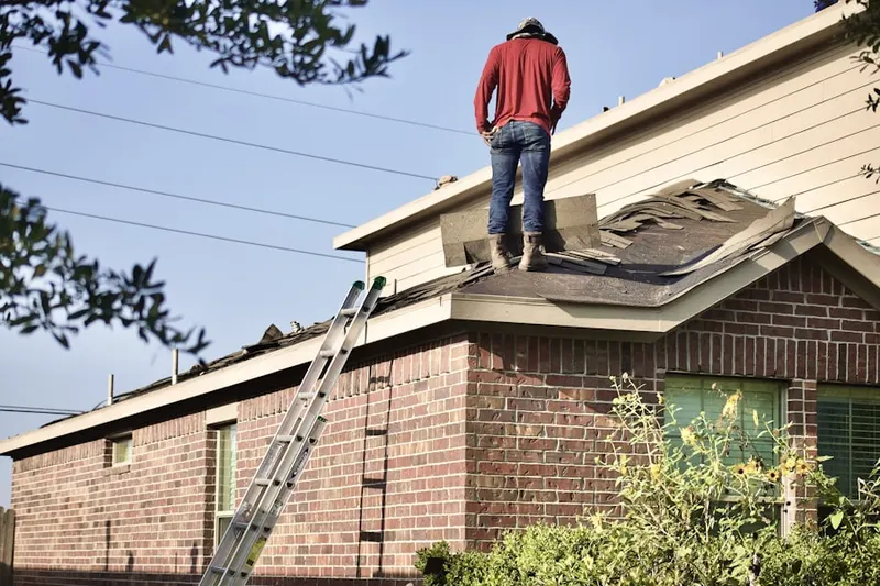 Professional roofer working on a residential roof in Lynn Woods
